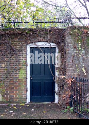 Schwarze Tür, die von Prinzessin Diana, Prinz William und Prinz Harry für geheime Besuche in den Kensington Gardens benutzt wurde. Kensington Palace, London, England. Stockfoto