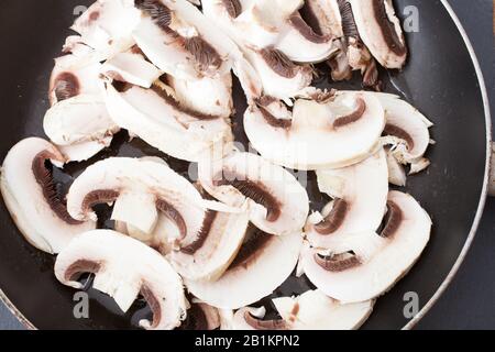 Champignons in Scheiben, die in einer Pfanne braten Stockfoto