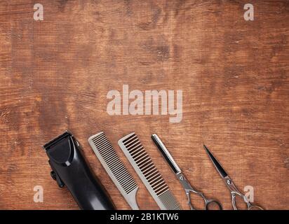 Werkzeuge zum Schneiden von Friseur-Haarschnitten auf dunklem Hintergrund. Ein gefährlicher Rasierer, eine Schreibmaschine, ein Haarschneider. Stockfoto