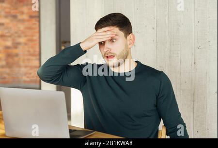 Überarbeiteter Mitarbeiter, Der Im Büro Im Schockzustand Auf Laptop Blickt Stockfoto