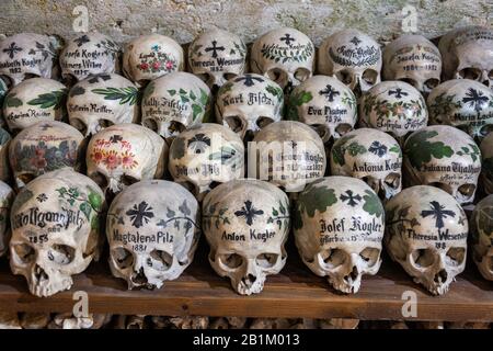 Hallstatt, Österreich - 9. Juli 2016. Reihen gestapelter Schädel im Beinhaus Chernel House in der St. Michael Kapelle von Hallstatt. Eine kleine Kapelle wurde verfüllt Stockfoto