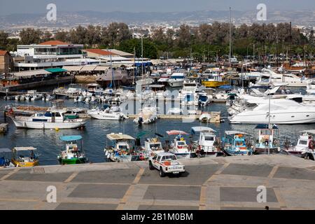 Traditionelle zyprische Fischerboote neben modernen Luxusyachten im Hafen von Paphos. Zypern 2018. Stockfoto
