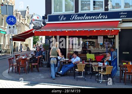 Amsterdam, Niederlande - 13. Juni 2006: Unidentifizierte Menschen und Kellnerin in einem kleinen Straßencafé an der Ecke im Zentrum der Stadt Stockfoto