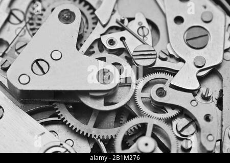 Uhrwerk, schwarz-weiße Zahnräder in einer Uhr. Teamwork-Konzept, Idee, Technologie, Ewigkeit, Business. Makro. Minimaler Designstil, Retro Style Stockfoto