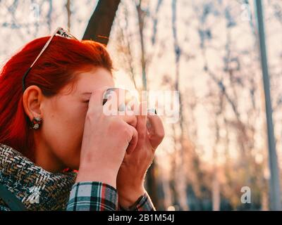 Person mit Kamera im Herbst. Red Hair Woman mit Retro-Photokamera. Fotoklassen Stockfoto