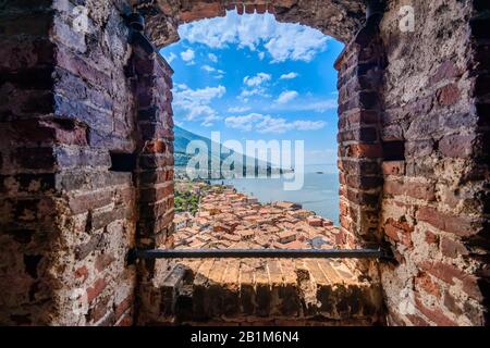 Blick durch das Fenster des Castello Scaligero in Malcesine auf die Südseite des Gardasee an einem hellen Mai-Morgen Stockfoto