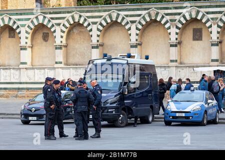 Florenz, Italien - 02. April 2019: Gruppe von Carabinieri diskutiert in der Nähe ihrer Fahrzeuge auf einem Stadtplatz der Altstadt. Stockfoto