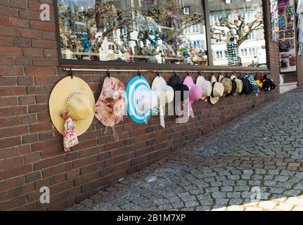 Schöne, mehrfarbige Sommer-Modenhüte aus natürlichen Materialien sind im Sommer bei sonnigem Wetter auf der Straße der antiken Stadt im Handel. Ou Stockfoto