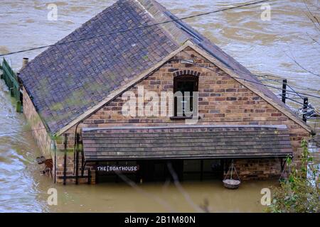 Ironbridge, England, 26. Februar 2020. Die Wharfage in Ironbridge wurde todat evakuiert. Auf der Südseite des Flusses ist ein Bootshaus leichter. Eine Nacht führte dazu, dass sich die Hochwasserschutzanlagen untl verschoben, sie schlugen die Bordsteinkante ein, erlitten aber keine erheblichen Verletzungen. Das Südufer ist nicht durch Schranken geschützt. Kredit: Malcolm Locker/Alamy Live News Stockfoto