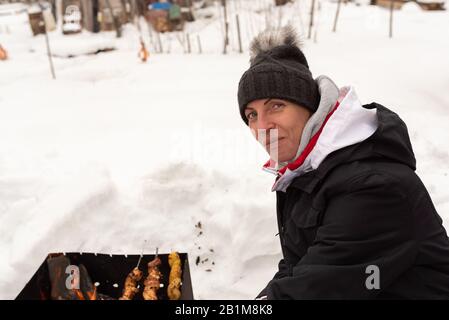 Eine Frau mit einer Schashlik auf einem Shampoo, im Winter. Stockfoto