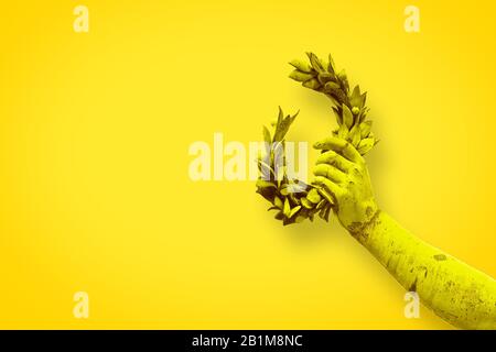 Hand hält einen Lorbeerkranz - Bronzestatue auf festem Farbhintergrund - Erfolg- und Ruhmkonzept Bild mit Kopierraum Stockfoto