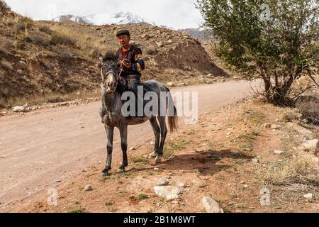 Naryn Region, Kirgisistan - Oktober 05, 2019: Kirgisischen ein Pferd reiten. Ein Mann reitet ein Pferd entlang der Kokemeren River. Stockfoto