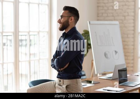 Erfolgreicher arabischer Unternehmer mit Blick auf das Fensterdenken fühlt sich zufrieden Stockfoto