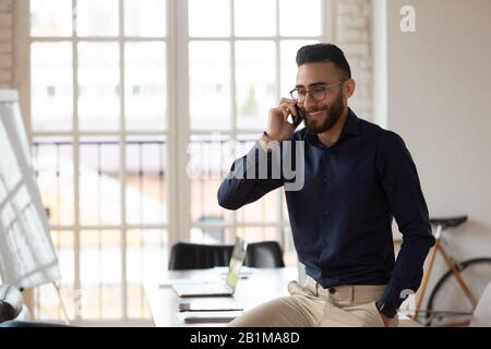 Mitarbeiter aus dem mittleren Osten innerhalb des Sitzungssaals telefonieren Stockfoto