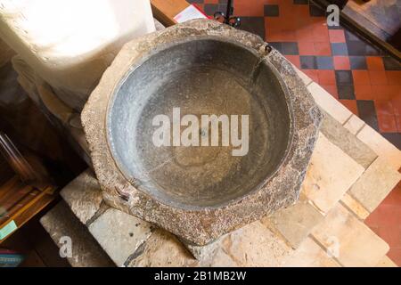 Achteckiges, aus Purbeck-Marmor geschnitztes, steinernes, spätnormannisches Taufbecken aus dem 12. Jahrhundert im Inneren der Kirche Bosham Holy Trinity. Bosham, West Sussex. GROSSBRITANNIEN. (114) Stockfoto