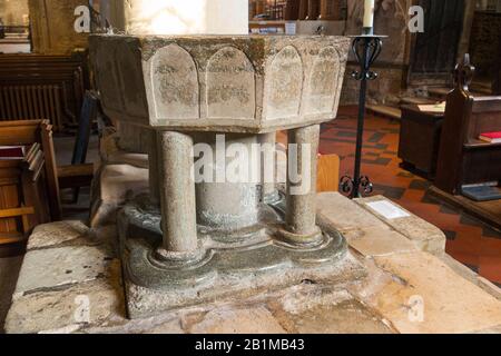 Achteckiges, aus Purbeck-Marmor geschnitztes, steinernes, spätnormannisches Taufbecken aus dem 12. Jahrhundert im Inneren der Kirche Bosham Holy Trinity. Bosham, West Sussex. GROSSBRITANNIEN. (114) Stockfoto