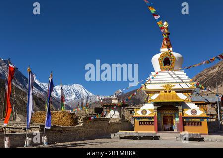 Massives riesiges buddhistisches Stupa-Denkmal und verschneite Himalaya-Bergspitzen im Manang Nepal Village auf Annapurna Circuit Wandertour Stockfoto