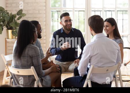 Verschiedene Menschen sitzen im Kreis, die an Teambuilding-Aktivitäten teilnehmen Stockfoto