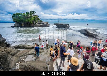 Besucher von Tanah Lot, einer Felsformation vor der indonesischen Insel Bali, die Heimat eines alten Hindu-Pilgertempels Pura Tanah Lot, Bali, Indonesien Stockfoto