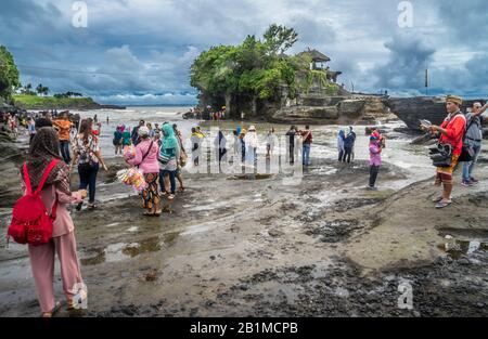 Besucher und Pilger in Tanah Lot, einer Felsformation vor der indonesischen Insel Bali, wo sich ein alter hinduistischer Pilgertempel Pura Tanah Lot, Bal, befindet Stockfoto