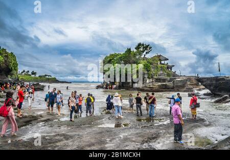 Besucher und Pilger in Tanah Lot, einer Felsformation vor der indonesischen Insel Bali, wo sich ein alter hinduistischer Pilgertempel Pura Tanah Lot, Bal, befindet Stockfoto