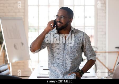 Afrikanischer Geschäftsmann telefoniert im modernen Büro Stockfoto