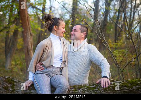 Schöne Paar zusammen sitzen auf dem Baum im Park umarmen Stockfoto