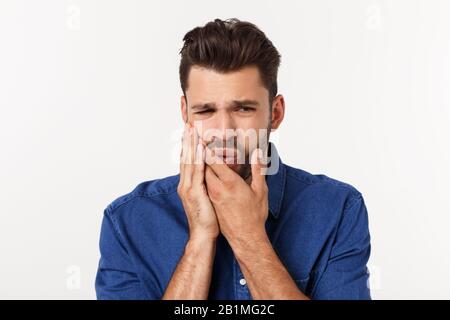 Nahaufnahme des enttäuschten gestressten bärtigen jungen Mannes im Hemd über weißem Hintergrund. Stockfoto