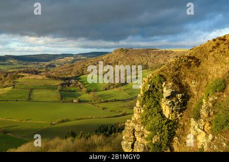 Schöne Fernsicht auf das sonnenbeleuchtete Sutton Bank Escarpment, Roulston Scar Cliff Face, Farmland & Dark Sky - North Yorkshire, England, Großbritannien. Stockfoto