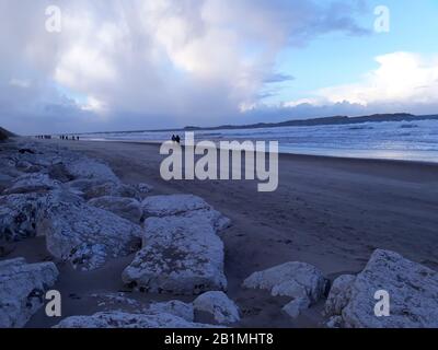 Menschen, die am Whiterocks Beach, Portrush, County Antrim, N. Ireland spazieren gehen Stockfoto