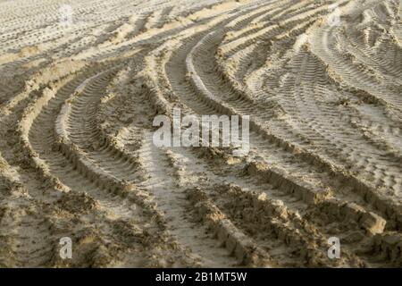 Reifenspuren auf Sandboden auf dem Bauhof. Lizenzfreies Foto. Stockfoto