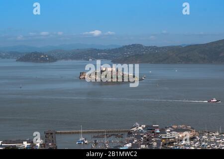 Alcatraz Island aus der Ferne mit Booten, die um sie kreisen. Lizenzfreies Foto. Stockfoto