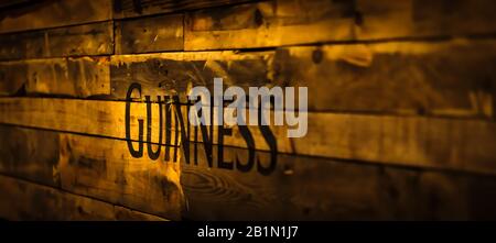 Dublin, Irland, Dezember 2017 Selective Focus on Guinness sign in Vintage or Grungy style on Holzbohlen. Guinness ist ein ikonisches irisches Bier Stockfoto
