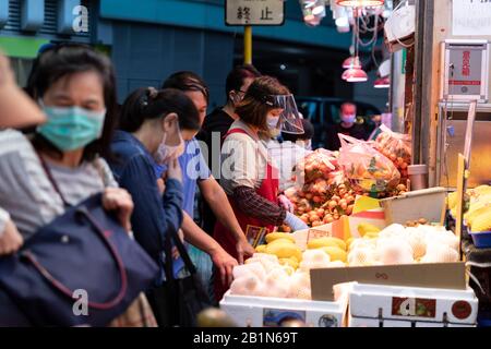 Menschen, die Schutzmasken auf dem nassen Markt im Central District tragen.Finanzsekretär Paul Chan gab bekannt, dass die Prognose für die Staatsausgaben die Einnahmen um 139 Milliarden HK im Jahr 2020-21 übersteigen soll, das Defizit wird für sechs Jahre in Folge prognostiziert. Stockfoto