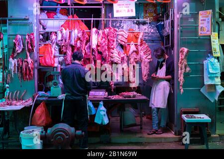 Menschen, die Schutzmasken auf dem nassen Markt im Central District tragen.Finanzsekretär Paul Chan gab bekannt, dass die Prognose für die Staatsausgaben die Einnahmen um 139 Milliarden HK im Jahr 2020-21 übersteigen soll, das Defizit wird für sechs Jahre in Folge prognostiziert. Stockfoto