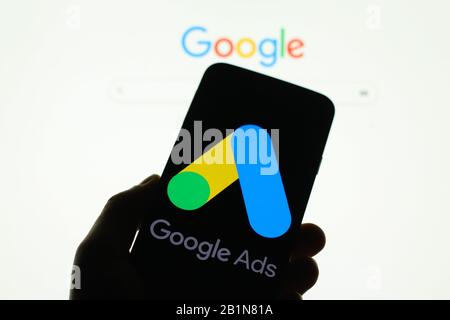 Google-Werbeanzeigen-Logo wird auf dem Smartphone-Bildschirm angezeigt, wobei die Google-Suchmaschine im Hintergrund verschwommen zu sehen ist Stockfoto