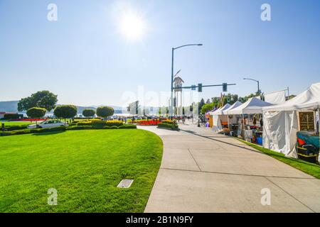 Verkäufer und Künstler errichteten an der Sherman Ave. Verkaufsstände mit dem Resort und dem See in der Ferne während eines lokalen Kunstfestivals, Coeur d'Alene, Idaho. Stockfoto