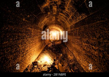 Dunkel und cremefarben alter historischer Gewölbeüberschwemmungstunnel im Untergrund. Stockfoto