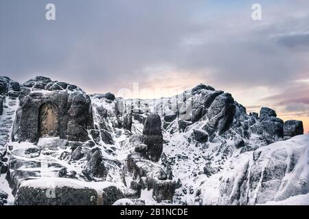 Nossa Senhora da Boa Estrela, eine religiöse Skulptur, die im Felsen in der Nähe der Spitze der Serra da Estrela (Portugal) gehauen ist, fotografiert im Winter bei Sonnen Stockfoto