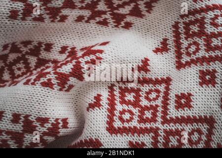 Details zu skandinavisch-roten Motiven an einer Strickjacke gestrickt Stockfoto