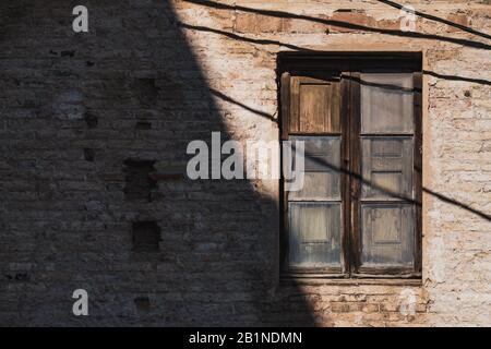 Altes Holzfenster eines alten roten Ziegelbaus Stockfoto