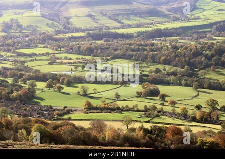 Sonnenschein über grünen Feldern und Herbstbäumen in Hope Valley, Peak District National Park, Derbyshire, England, Großbritannien Stockfoto