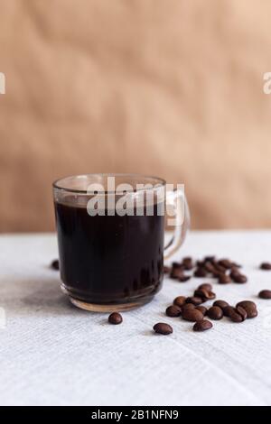 Eine Tasse schwarzen Kaffee und Bohnen auf Marmorgrund Stockfoto
