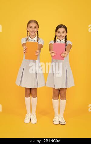 Schule Bibliothek. Homeschooling Konzept. Alphabetisierung Club. Süße Kinder holding Bücher auf gelben Hintergrund. Kleine Mädchen mit Lexikon oder Bücher der Kinder. Pädagogische Bücher für Schulen. Bücher zu lesen. Stockfoto