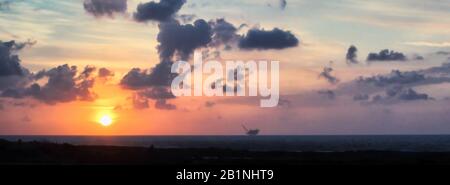 Ein computergroßes Banner zeigt Israels Küste bei Sonnenuntergang mit der Leviathan-Erdgasanlage in der Ferne. Stockfoto