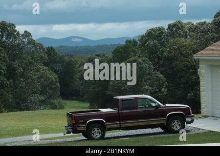 Pickup-Truck in der Einfahrt eines Hauses geparkt. Blick auf das LU-Monogramm (Liberty University) am Liberty Mountain in Lynchburg, Virginia, USA. Stockfoto