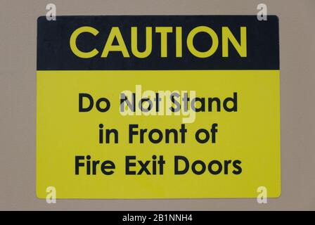 "Achtung: Stellen Sie sich nicht vor die Brandschutztüren, um die Tür zugänglich zu halten." Warntext und Hinweisschild Stockfoto