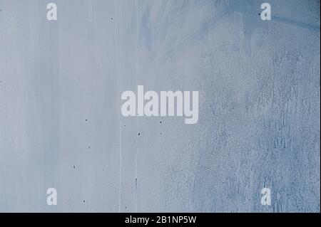 Wandtextur aus blauem Beton mit Rissen und Unebenheiten und Spuren von Fließwasser Stockfoto