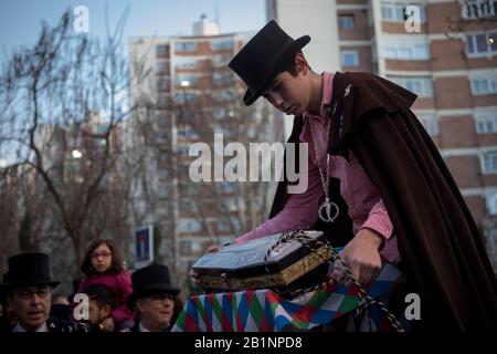 Ein junges Mitglied der Bruderschaft der Sardine bereitet den Sargsarg für eine Einweihungsfeier für die neuen Mitglieder der Bruderschaft während der Prozession vor. Die Sardinische Prozession, die in Madrid stattfindet, ist eine jahrhundertealte spanische Tradition, die durch ein Gemälde des spanischen Künstlers Francisco de Goya berühmt wurde, das "Die Bestattung der Sardine" genannt wird. Es markiert das Ende der Karnevalsfeiern und den Beginn der Fastenzeit 40 Tage vor Ostern. Es besteht aus einer Prozession, die eine Beerdigung parodiert, bei der eine symbolische Figur einer Sardine in ihrem Sarg verbrannt wird. Die Festlichkeit findet z. Stockfoto