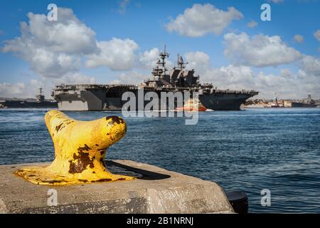Eine Klatsche für Schiffe im Hafen von San Diego, Kalifornien, mit einem Schiff der US Navy, das im Hintergrund auf See unterwegs ist. Stockfoto